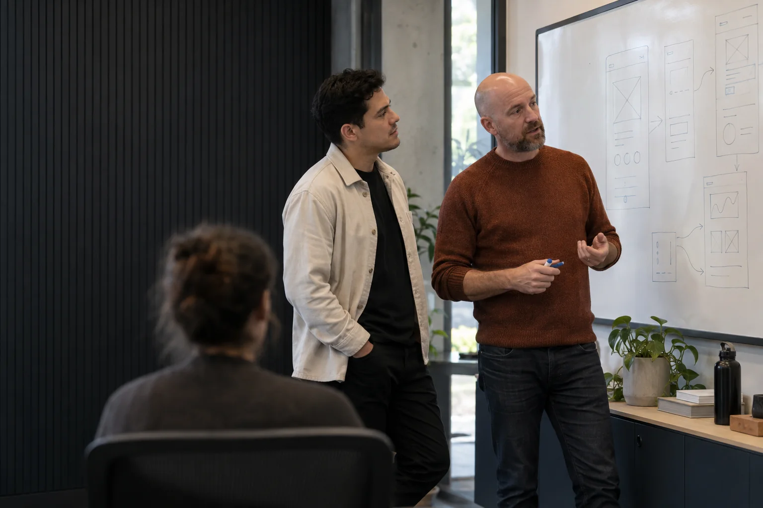 Product and engineering colleagues reviewing their work in a modern operations studio.